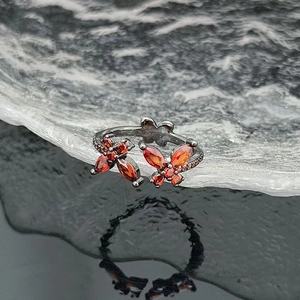 Macro shot of twin butterfly zircon ring with red marquise stones and gun black metal