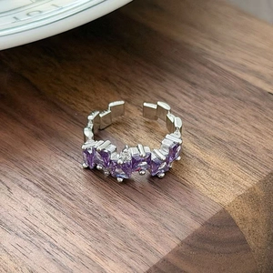 Detail of adjustable silver ring with purple square zircons and geometric band design