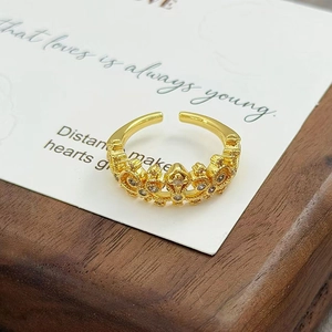 Gros plan d'une bague couronne vintage dorée sertie de zircons avec design ouvert