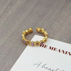 Macro detail van vintage vergulde hartring met paars email en zwarte zirkonia