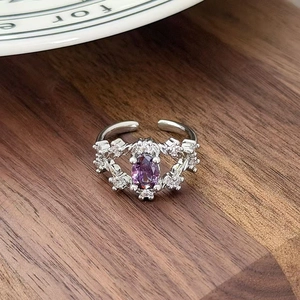 Close-up of vintage adjustable silver ring with oval purple gemstone and white zircons