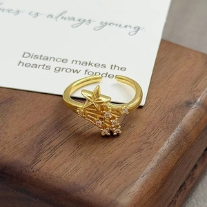 Vue détaillée d'une bague étoile vintage en or avec zircons sur base en bois sombre