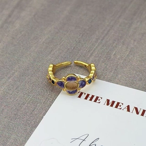 Detailopname van vintage paarse emaille ring met bruine edelsteen en blauwe steen
