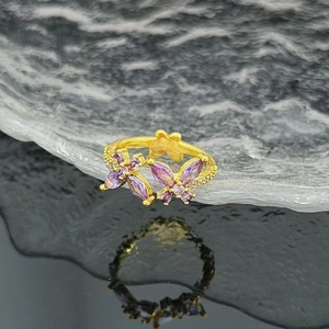 Macro shot of purple marquise zircon butterfly wings on a gold adjustable open ring