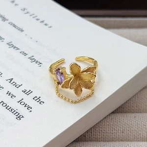 Detail eines Vintage Goldblumenrings mit lila Zirkonia und Perlenkettendesign
