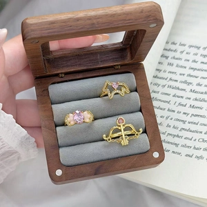 Tre anelli vintage dorati con zirconi rosa in un elegante cofanetto in legno pregiato