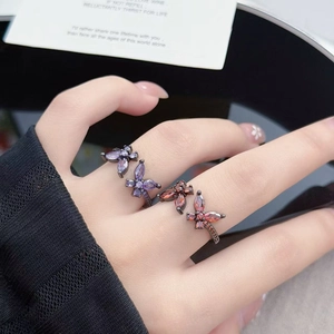 Macro detail of butterfly ring with purple and pink marquise stones on a model hand