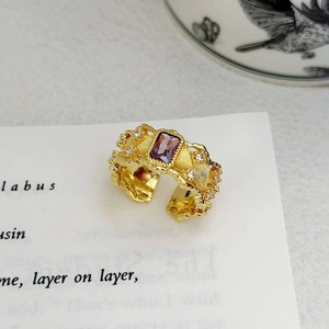 Makroaufnahme eines Vintage-Rings aus vergoldetem Messing mit violettem Zirkon und Gravuren