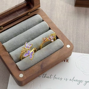 Details van vintage gouden ringen met paarse emaille vlinder en bloemmotieven met zirkoon