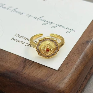 Détail d'une bague vintage en or avec pierre centrale orange et pavé de zircons