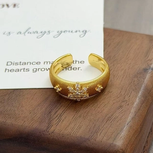 Détail macro d'une bague dorée vintage avec zircon en étoile et texture métal brossé