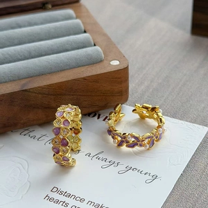 Detail van vintage paarse emaille ringen met parels en gouden bloemendetails op de band