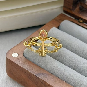 Dettaglio dell'anello vintage dorato con arco e freccia e zircone rosa a forma di cuore
