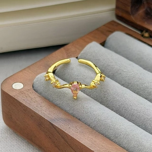 Dettaglio anello con zircone rosa a goccia in una scatola portagioie in legno e velluto