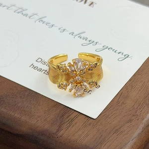 Détail d'une bague fleurie en zircon doré avec texture vintage sur carte blanche