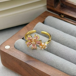 Dettaglio anello vintage dorato con zircone rosa e fiore di perla in scatola legno