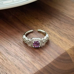 Detailed macro view of a vintage silver ring with a square purple zircon and small crystals