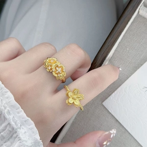 Gros plan de bagues fleurs vintage avec incrustation de zircon et pétales dorés texturés