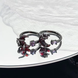 Dettaglio di anelli gotici con placcatura nera, design luna pipistrello e gemme viola