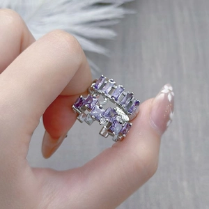 Detailed view of silver rings featuring baguette-cut purple zircon stones worn on hand