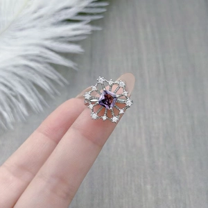 Macro detail of silver ring with square purple zircon and snowflake pavé setting