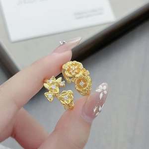 Vue détaillée d'une bague fleur dorée vintage avec zircons sur surface texturée