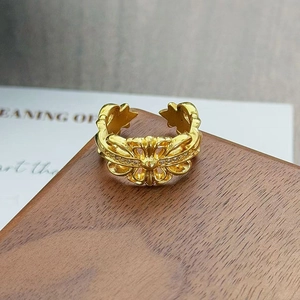Détail de la bague ouverte dorée vintage avec motif de croix gothique et zircons