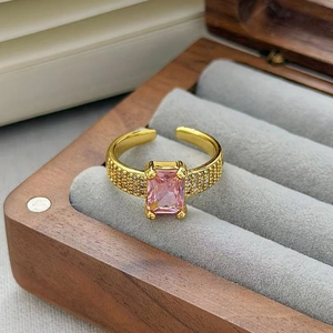 Dettaglio dell'anello con zircone rosa, fascia dorata e cristalli pavé