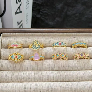 Lot de 8 bagues vintage en émail aux motifs floraux et de gourde dans un écrin à bijoux