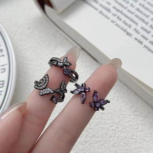 Gros plan d'un ensemble bijoux papillon avec zircons violets sur un doigt