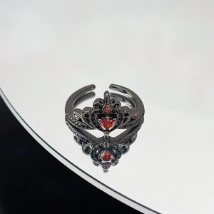 Dettaglio macro dell'anello corona gotico nero con gemma a cuore rosso e zirconi fini