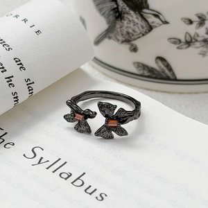 Macro d'une bague papillon noire vintage avec gemmes orange et anneau texturé