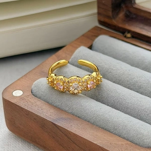 Dettaglio anello vintage dorato con zirconi rosa e design a grappolo floreale