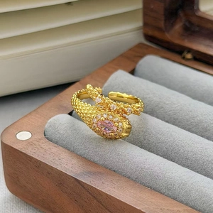 Dettaglio dell'anello a serpente dorato con zircone rosa in una scatola regalo di velluto