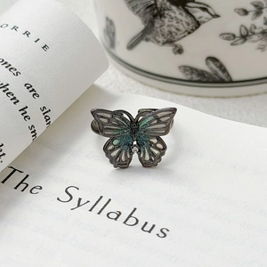 Détail de la bague papillon émaillée vintage sur page de livre au style punk gothique