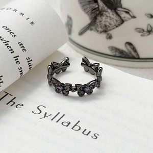 Détail d'une bague papillon vintage avec pierres violettes sur une page de livre