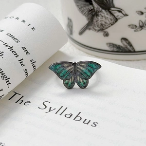 Détail de la bague papillon punk vintage avec ailes en émail vert et fini noir