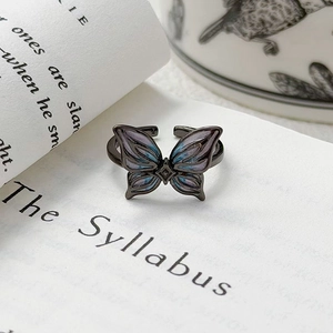 Détail d'une bague papillon ajustable avec émail bleu-violet sur métal noirci