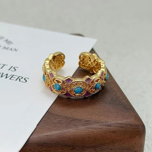 Détail de la bague vintage dorée avec émail violet et incrustation de pierre bleue