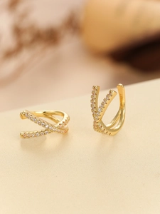 Macro shot of 18K gold plated cross ear cuff with micro-pave cubic zirconia stones