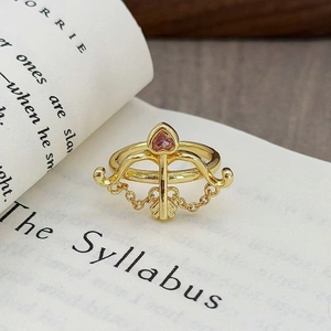 Dettaglio dell'anello vintage a arco con zircone a cuore rosa su un libro inglese