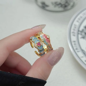 Détails rapprochés de bagues vintage en émail avec motifs de nuages colorés et zircons