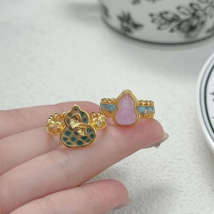 Vue détaillée macro d'une bague vintage dorée avec émail bleu et motif de feuille de ginkgo