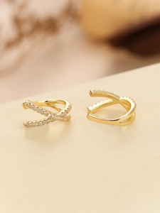Close-up of gold-plated criss-cross ear cuffs featuring micro-pave cubic zirconia stones
