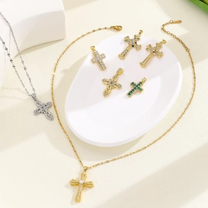 Detailed close-up of religious cross pendants with colorful zircon inlay on stone surface