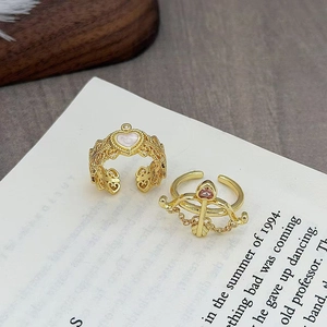 Dettaglio di anelli aperti vintage con zircone a cuore su carta con poesie romantiche