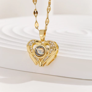 Macro detail of gold heart projection necklace with zircon stones and leaf link chain
