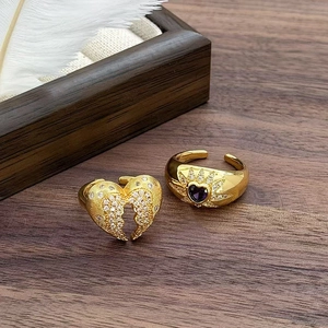 Dettaglio di anelli vintage placcati in oro a forma di cuore con zirconi su un vassoio