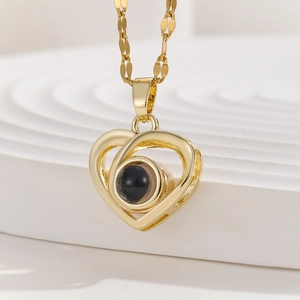 Detail of gold heart pendant with black projection stone on wave textured display
