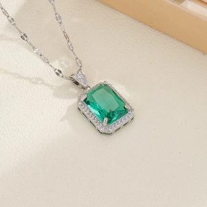 Elegant emerald cut green gemstone necklace with pavé diamond halo in silver finish